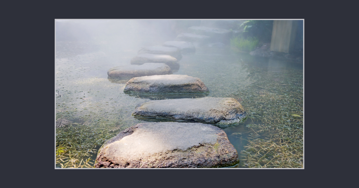 Stepping stones crossing calm water, symbolizing simple steps to start end-of-life planning and get your affairs in order.